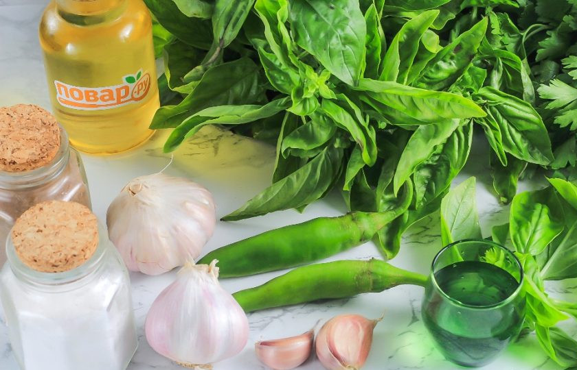 1. Этап. Аджика из базилика: Подготовьте указанные ингредиенты. На крупный пучок зеленого базилика вам примерно понадобятся 4-5 крупных зубчиков чеснока и 2 мелких стручка острого перца.