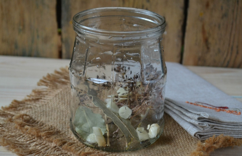 1. Этап. Маринованные кабачки на зиму: 5. На дно чистых банок сложите все специи: укроп, чеснок, лавровый лист и перец горошком.