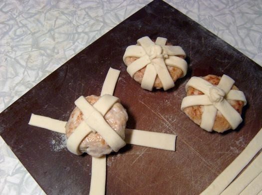 1. Этап. Фарш в тесте: Для того чтобы их оплести тестом, мы тесто нарезаем на узкие полоски. Длина полосок 15 см. Полоски кладем лучами внахлест. Можно брать три или четыре полоски, в зависимости от этого пространство между плетенкой будет больше или меньше. Лучи соединяем в центре над котлетой, формируя «пуговку», получается «бубенчик».