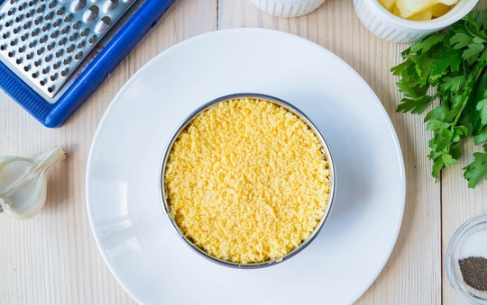 1. Этап. Салат Дамский каприз с курицей: Последним слоем выкладываем измельченные желтки.