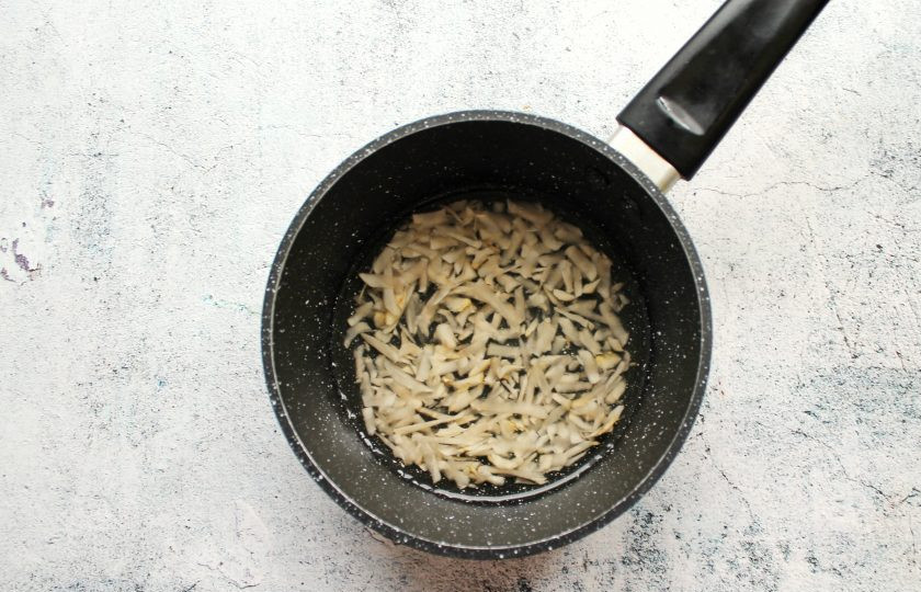 1. Этап. Каша с топинамбуром: Воду налейте в кастрюлю с толстым дном и доведите до кипения. Топинамбур вымойте, очистите от кожуры и натрите на крупной или средней терке. Выложите в кастрюлю и варите в течение 5 минут.