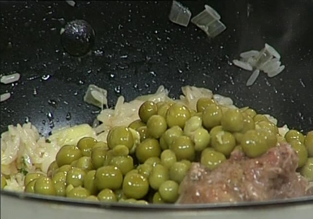 1. Этап. Кабачки с тушенкой: Следующий шаг: кладем на сковороду тушенку и горошек. Тщательно перемешиваем.