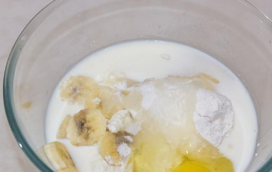 1. Этап. Оладьи из творога и банана: Выложите в миску творог, нарезанный банан, яйцо, сахар, манку, молоко, ванилин, соль и муку.