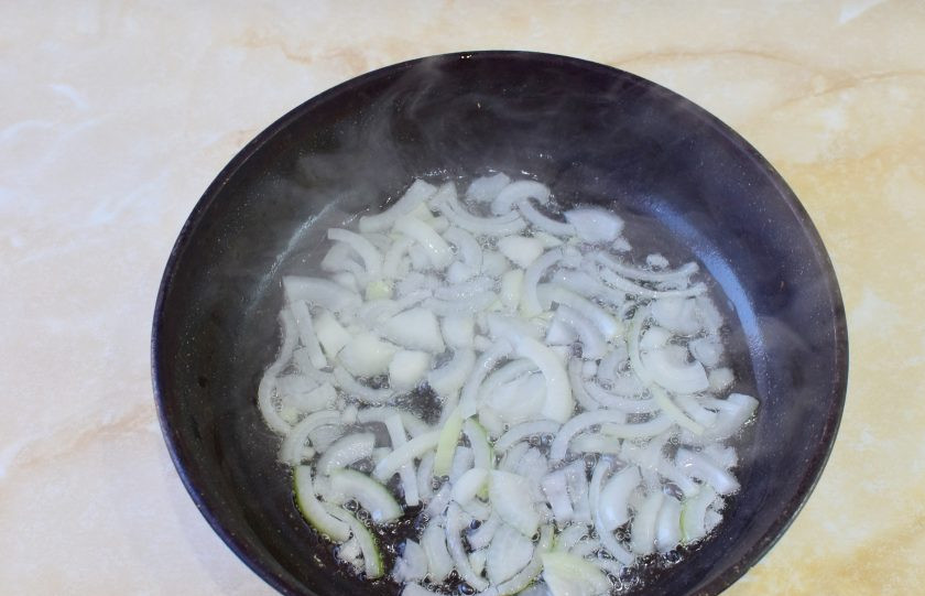 1. Этап. Куриная печень с макаронами: В горячую сковороду налейте немного растительного масла и обжарьте лук в течение минуты. Он станет прозрачнее.