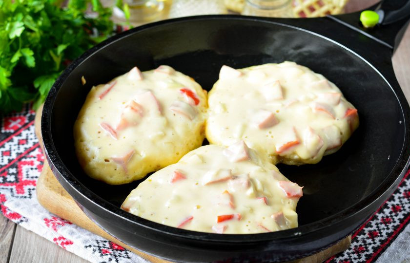 1. Этап. Оладьи-пиццы на молоке: Разогрейте немного масла на сковороде, выложите оладьи-пиццы при помощи ложки и жарьте 4-5 минут на огне чуть меньше среднего. За счет соды оладьи станут пышными.