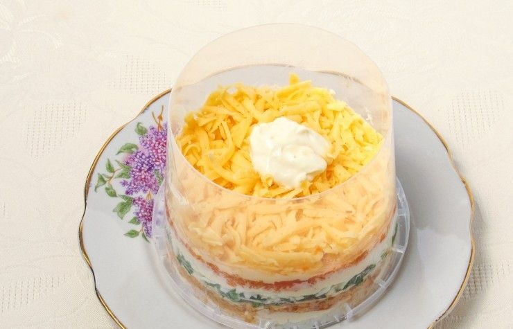 1. Этап. Салат Мимоза с рисом и сыром: 8. Поверх моркови кладу слой твердого сыра, смазываю тонким слоем майонеза. Отправляю салат на 60 минут в холодильник, после этого аккуратно достаю форму.