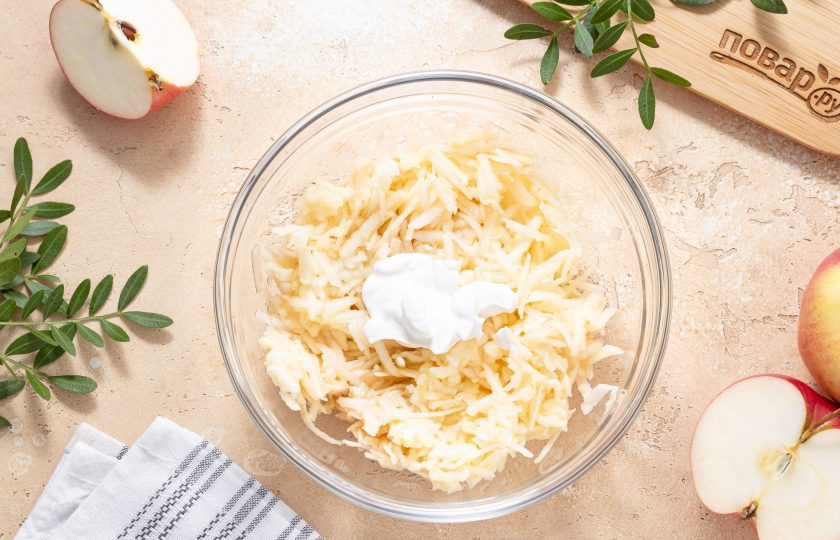 1. Этап. Драники из яблок: Добавьте сметану и перемешайте.