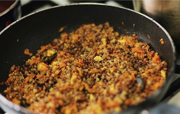 1. Этап. Перец, фаршированный сыром и гречкой: Адыгейский сыр мелко раскрошить, морковь натереть не терке. В сковородке разогреть масло и обжарить в нем специи, затем выкладываем морковь. Через 5-7 минут присоединить морковь с сыром. Обжаривать еще несколько минут, а затем засыпать промытую гречку, немного подержать на огне и залить водой в пропорции 1:2, накрыть крышкой, уменьшить огонь до минимума и тихонечко тушить до готовности.