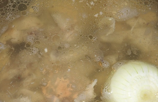 1. Этап. Картофельный суп на курином бульоне: 3. В кипящий бульон отправьте куриное филе и луковицу целиком.