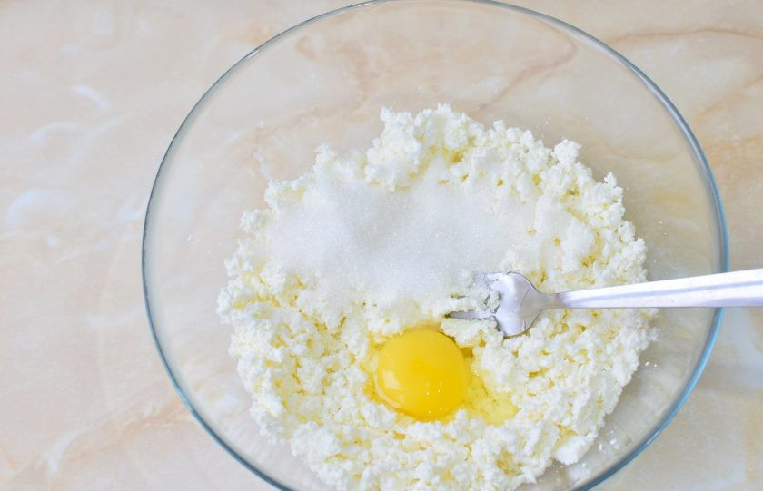 1. Этап. Сырники в мультипекаре: Затем вмешайте в творог сахар и яйцо.