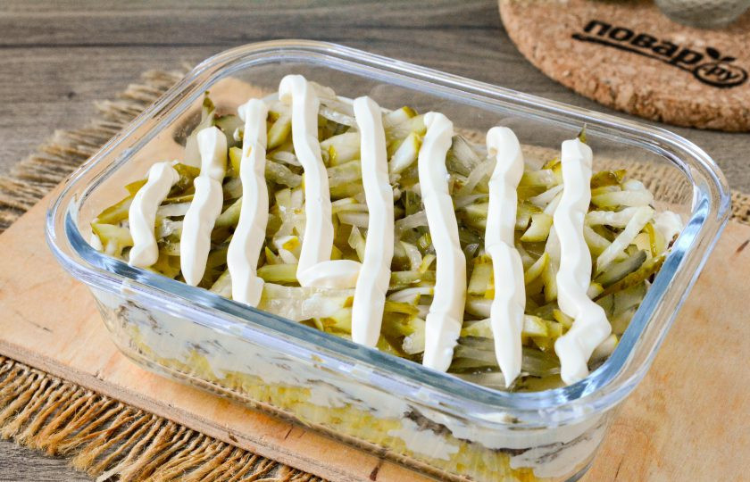 1. Этап. Салат Президент с мясом: Соленые огурцы нарежьте соломкой и выложите следующим слоем поверх мяса. Огурцы полейте майонезом с чесноком.