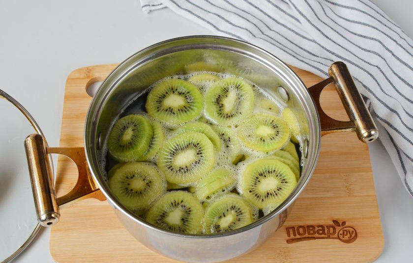 1. Этап. Цукаты из киви: В кипящий сироп выложите киви, на самом маленьком огне проварите до минуты. Снимите с плиты, оставьте остывать, крышкой накрывать не нужно.
