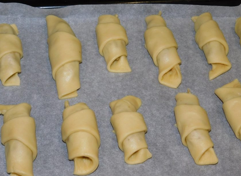 1. Этап. Рогалики с грецкими орехами: Скрутите рогалики. Выложите на противень, застеленный пергаментом, и поставьте в духовку, разогретую до 200 градусов, на 15 минут.