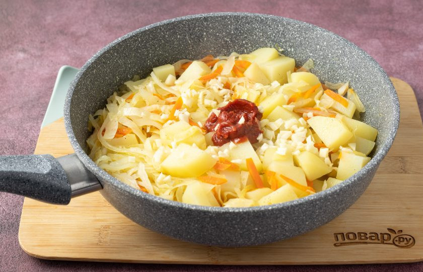 1. Этап. Рагу по-крестьянски: Добавьте томатную пасту и измельченный чеснок. Аккуратно перемешайте.