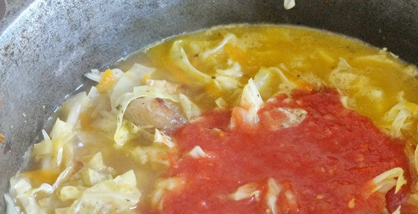 1. Этап. Тушеная капуста в казане со свининой: Переложите нашинкованную капусту в казанок к свинине с овощами, добавьте ложку томатной пасты, которую с легкостью можно заменить на стакан томатного сока или же консервированные помидоры без кожуры. Посолите и поперчите блюдо. Тушите под закрытой крышкой на маленьком огне до готовности (30-40 минут), доливая воду при необходимости.