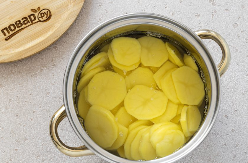 1. Этап. Постная картофельная запеканка с капустой: Картофель промойте, очистите от кожуры. Нарежьте на тонкие кружочки толщиной 2-3 мм. Отварите их в кипящей подсоленной воде до готовности. Здесь очень важно их не переварить, чтобы они не разваливались потом. Затем слейте воду и остудите картофель.