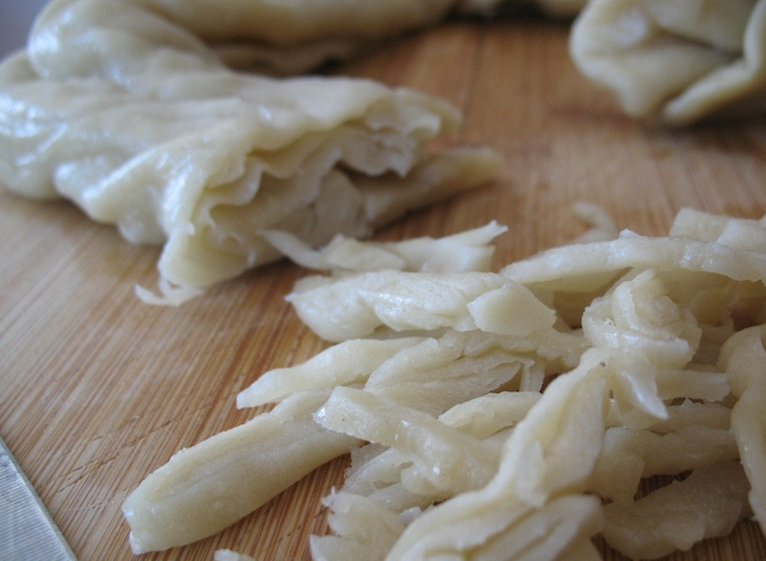 1. Этап. Цуйван: 10. Нарежьте рулетик тонкой соломкой, размешайте его руками.