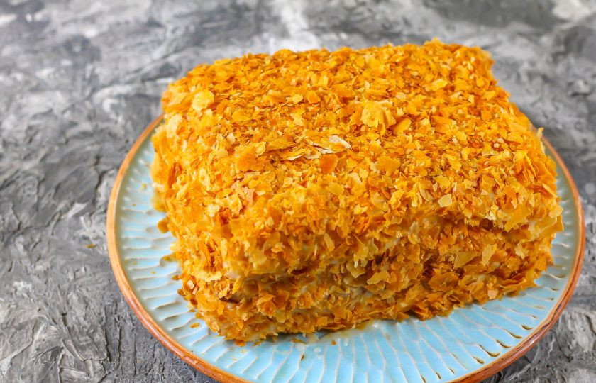 1. Этап. Ленивый Наполеон из слоеного теста: Присыпьте торт сверху и по бокам. Отправьте его в холодильник на 3-5 часов для пропитывания.