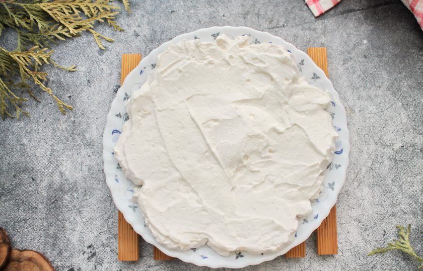 1. Этап. Торт из зефира с клубникой без выпечки: Сливки взбейте в пышную массу и смажьте верх зефирного слоя частью сливок.