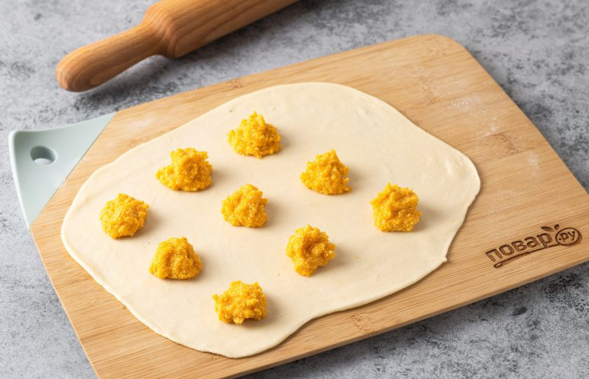 1. Этап. Равиоли с тыквой и рикоттой: Тесто разделите на две равных части. Обе раскатайте толщиной в пару мм. На один пласт выложите примерно по 1 ч.л. начинки на расстоянии друг от друга.