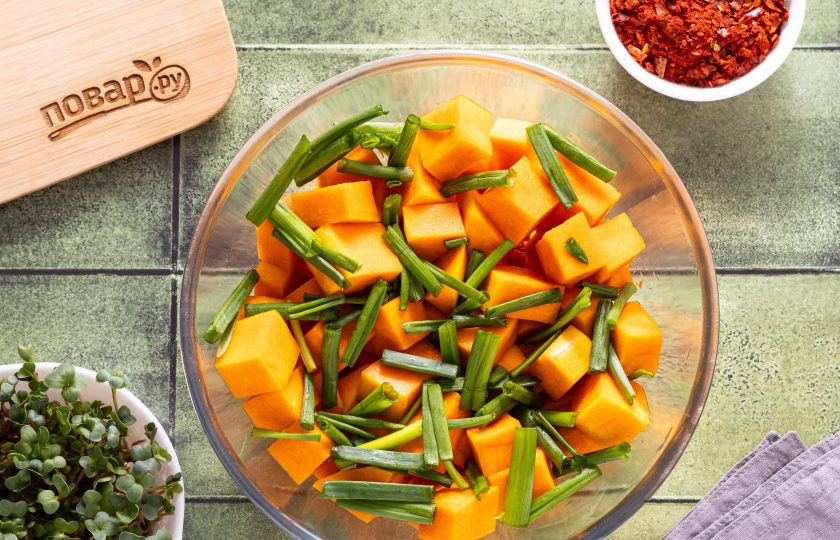 1. Этап. Кимчи из тыквы: Переложите тыкву в большую глубокую миску, добавьте нарезанный палочками зеленый лук.