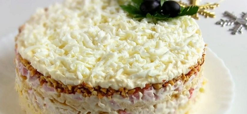 1. Этап. Салат на Новый год Снежная королева: 5. Половину натертых белков смешайте с майонезом и выложите на арахис. Сверху присыпьте второй половиной тертых белков. Дайте салату пропитаться несколько часов, после чего снимите кольцо и украсьте зеленью. Приятного аппетита!