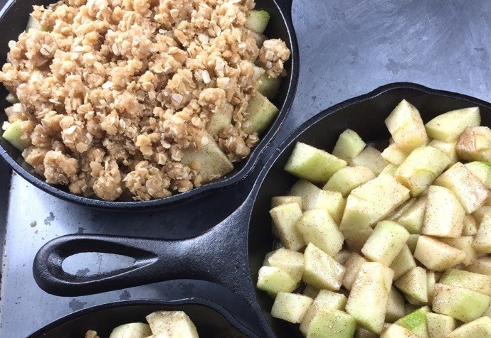 1. Этап. Десерт из яблока и овсянки: 6. Выложите яблоки на дно небольшой сковороды или специальной формочки. Сверху добавьте овсяно-мучную смесь.