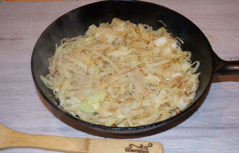 1. Этап. Пирожки с капустой духовые: Обжарьте капусту на растительном масле под крышкой. В процессе жарки посолите и поперчите её. Затем снимите с огня и остудите.