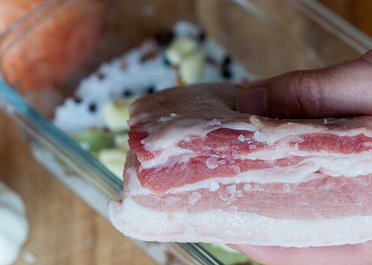 1. Этап. Засолка сала по-украински: 1. Примерно половину соли выложите в удобную форму или контейнер. Добавьте часть нарезанного чеснока и горсть перца. Сало вымойте и как следует обсушите.