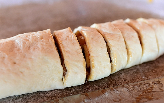 1. Этап. Булочки с яблоком и карамелью: 7. Сверните рулет и нарежьте его на несколько частей.