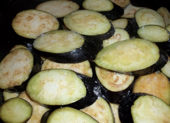 1. Этап. Баклажаны с гранатом: Нарежьте баклажаны кружочками, киньте в глубокую сковороду. Залейте растительным маслом и посолите.