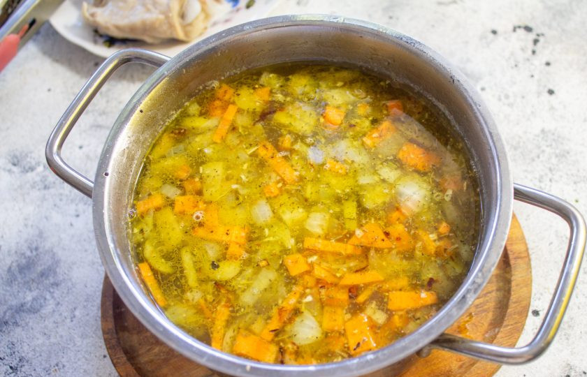 1. Этап. Куриный суп с солеными огурцами: В бульон к рису и картофелю отправьте овощную зажарку с огурцами. Варите вместе 5-7 минут.