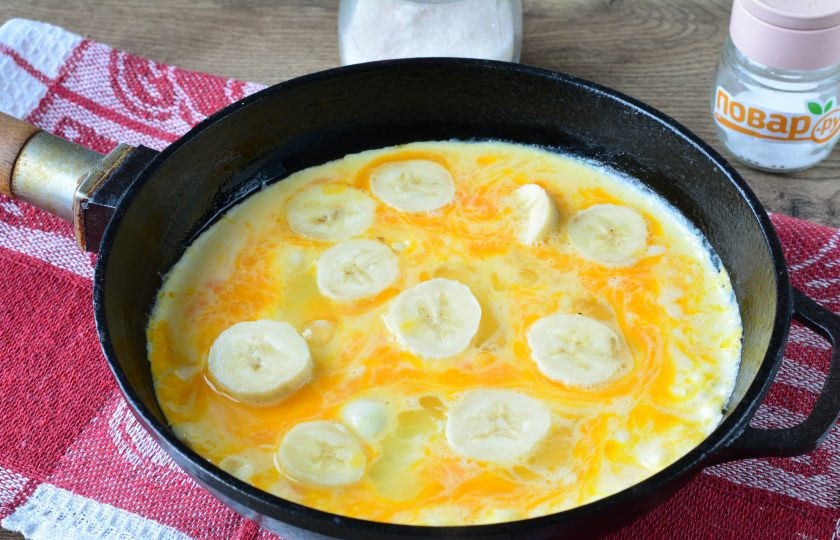 1. Этап. Омлет с бананом и сыром: Растопите масло на небольшом огне, влейте омлетную массу, выложите бананы.