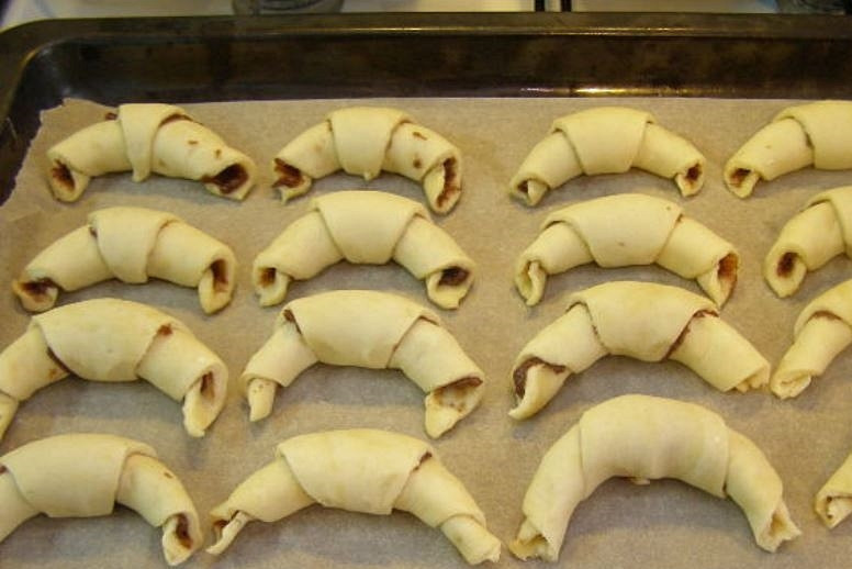 1. Этап. Рогалики с начинкой: Выложите печенье на противень и поставьте в духовку, разогретую до 200 градусов, на 15-20 минут.