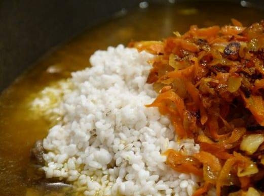 1. Этап. Плов из утки: В казан, в котором тушится утка, добавляем рис, обжаренную морковь и соль.