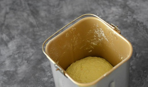 1. Этап. Лимонные булочки с песто: В ведёрко хлебопечки выложите заваренную поленту, добавьте дрожжи, масло, всыпьте пшеничную муку, соль и добавьте цедру и сок половинки лимона. Если хочется более интенсивного лимонного вкуса - то цедру возьмите с целого лимона. Включите на хлебопечке режим замеса и замесите тесто. С мукой история такая - мука бывает разной влагоёмкости, и её может потребоваться чуть больше или меньше указанного количества. Поэтому, если после замеса вы видите, что тесто жидковато - то по столовой ложке добавляйте муку и пусть хлебопечка её вмешает. Если тесто вышло слишком тугим - то по столовой ложке добавьте воду и повторите режим замеса. В итоге у вас должно выйти мягкое и эластичное тесто, не липнущее к рукам.