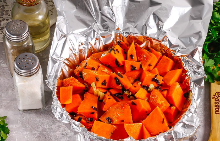 1. Этап. Тыква запеченная с базиликом: Застелите форму фольгой и выложите в нее тыквенную нарезку. Накройте фольгой так, чтобы не было отверстий. Прогрейте духовку до 200 градусов.