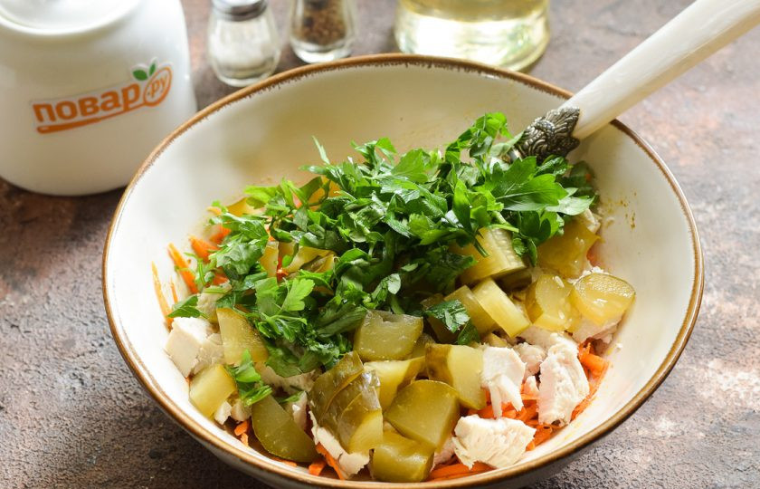 1. Этап. Салат с корейской морковью и маринованными огурцами: Петрушку ополосните и просушите, нарежьте мелко и добавьте в салат.