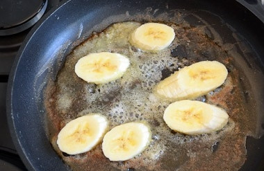 1. Этап. Жареные бананы с мороженым: Готовим на среднем огне. Когда смесь масла и сахара станет легкого карамельного цвета, выкладываем на сковороду ломтики бананов.