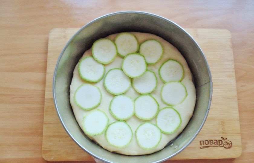 1. Этап. Испанская пицца: Кабачки вымойте и нарежьте кружками. Выложите на тесто.