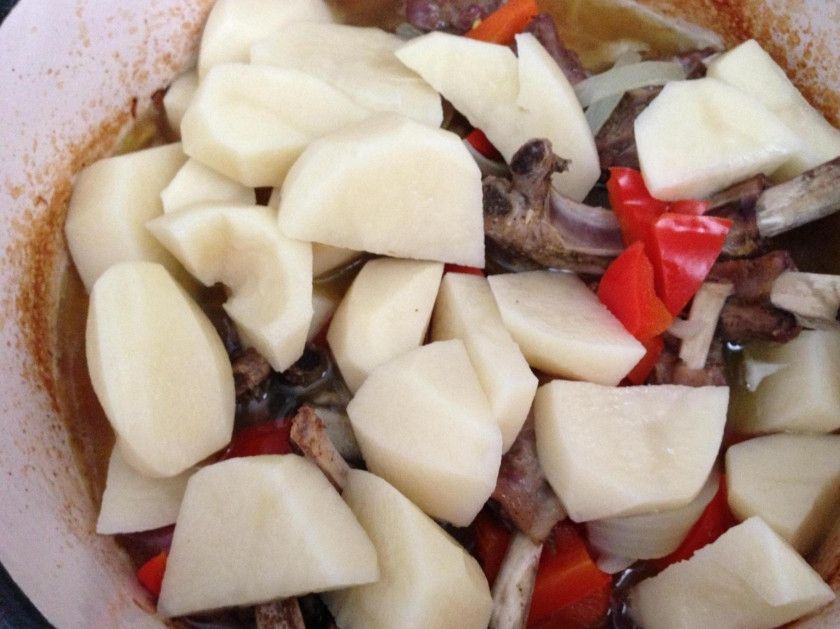 1. Этап. Корейка из баранины: 6. Затем достаю казан и отправляю в него крупно порезанную картошку, перец, солю и заливаю все водой, обратно ставлю в духовку.