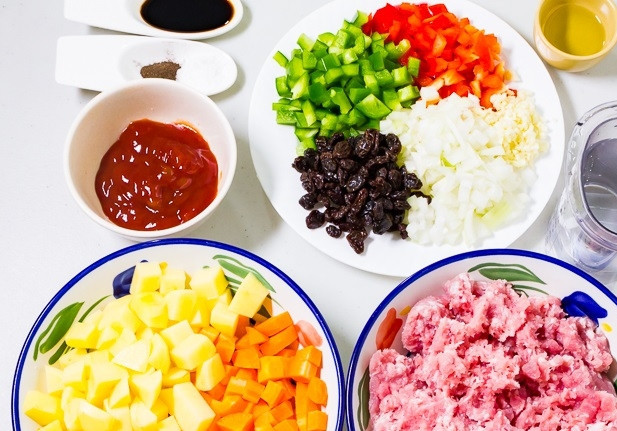 1. Этап. Свинина с изюмом: Нарежьте кубиками лук, перец, картофель и морковь. Чеснок измельчите.