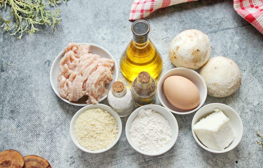 1. Этап. Шампиньоны с куриным фаршем в духовке: Подготовьте все необходимые ингредиенты для приготовления шампиньонов с куриным фаршем в духовке. Грибы оботрите влажной салфеткой, срежьте места загрязнения. Яйцо тщательно вымойте.