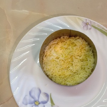 1. Этап. Салат Вкуснейший: Картофель натереть на мелкой терке и выложить в глубокий салатник.