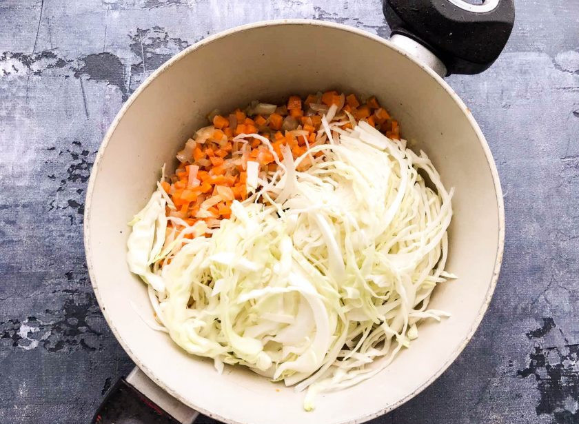 1. Этап. Овощное рагу с капустой и фасолью: Капусту мелко порубите и выложите к луку с морковью. Хорошо перемешайте и жарьте 5-6 минут на среднем огне.