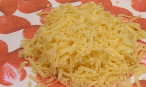 1. Этап. Нежный салат с кальмарами: 4. Возьмите кусочек твердого сыра. Освободите его от оболочки и натрите на крупной терке.