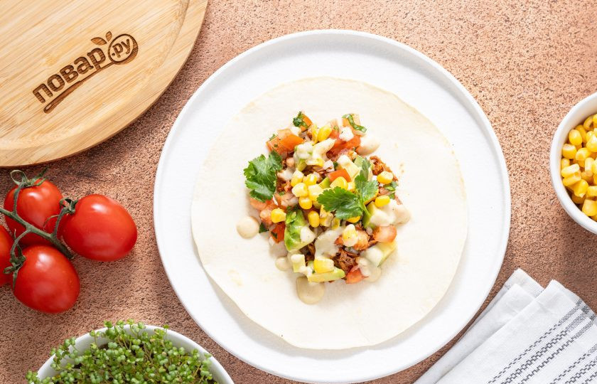 1. Этап. Веганское тако: Выложите на лепешку начинку, полейте соусом и посыпьте крупно порубленной кинзой.