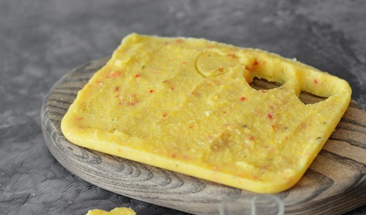 1. Этап. Канапе с лососем на кукукрузной поленте: Застывшая полента легко извлекается из контейнера. Выложите её на доску и при помощи формочки вырежьте основание для канапе. Можете просто ножом нарезать на квадраты или ромбы - так отходов будет меньше.