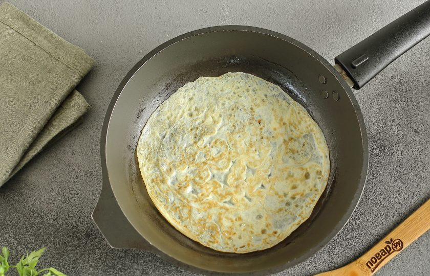 1. Этап. Салат с курицей и яйцами: Смажьте сковороду маслом. Налейте порцию взбитых яиц, распределите по всей сковороде в форме блинчика и обжарьте с двух сторон до готовности. Долго обжаривать не нужно, как только яичная масса схватится, переворачивайте. Таким образом приготовьте все яичные блинчики.