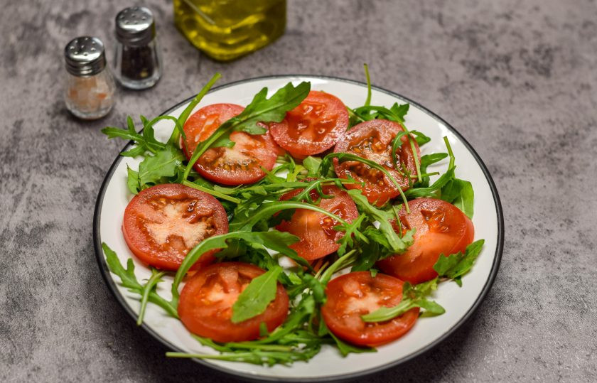 1. Этап. Салат с сыром косичка и сухариками: Рукколу ополосните и просушите, переложите на тарелку. Помидоры ополосните и нарежьте кружочками. Выложите помидоры и рукколу на тарелку.